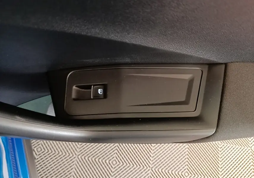 Détail de la commande de lève-vitre sur la porte intérieure côté conducteur d’un Volkswagen T-Roc bleu 2020.