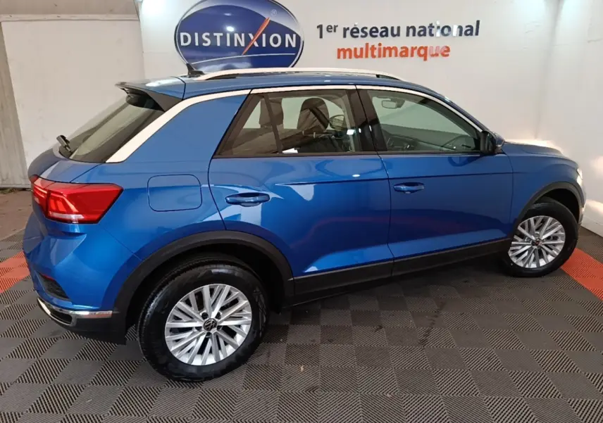 Vue latérale droite d'un Volkswagen T-Roc bleu 2020 avec jantes alliage et toit blanc contrasté.
