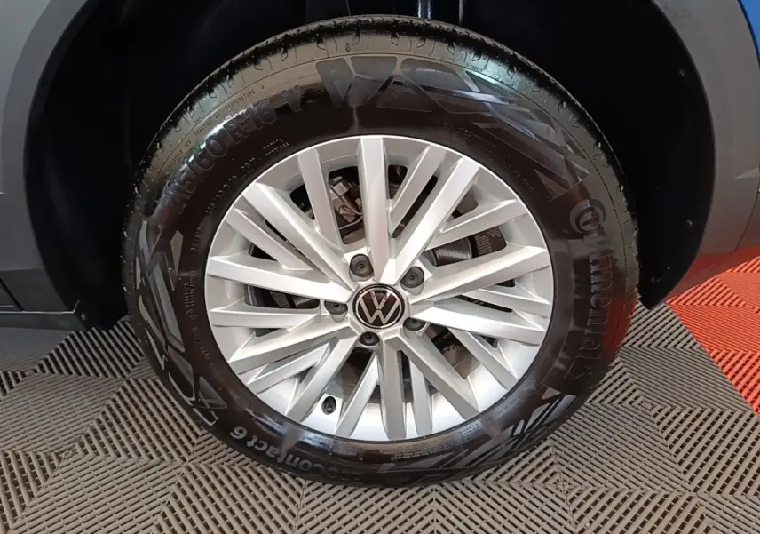 Gros plan sur la roue avant droite d’un Volkswagen T-Roc bleu, avec jante alliage argentée et pneu Continental.