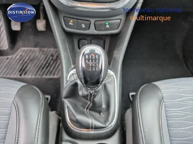 Gros plan sur le levier de vitesses manuel noir de l'Opel Mokka 2015, entouré des sièges avant en tissu gris.