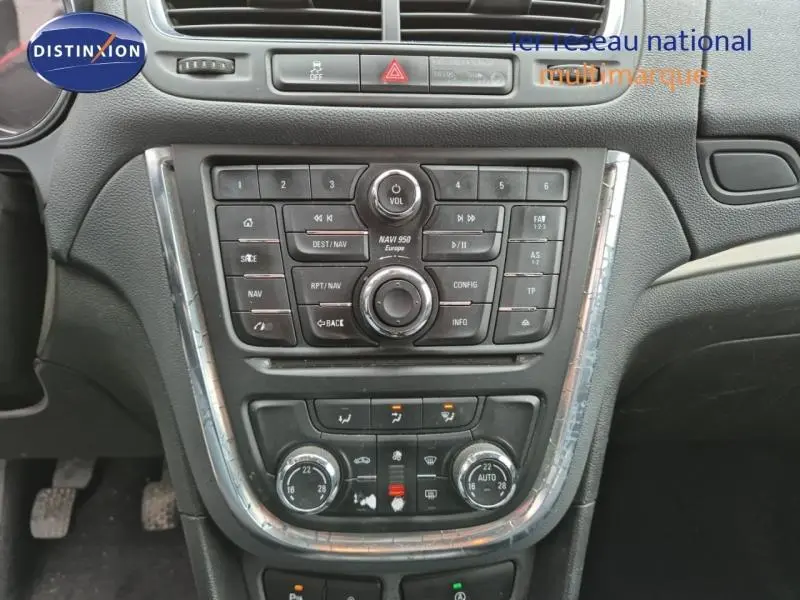 Vue rapprochée du tableau de bord central de l'Opel Mokka bleu outremer, avec commandes audio et climatisation.