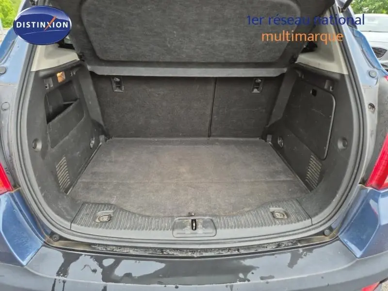 Coffre ouvert d’un Opel Mokka bleu outremer, montrant un espace de chargement propre et fonctionnel.