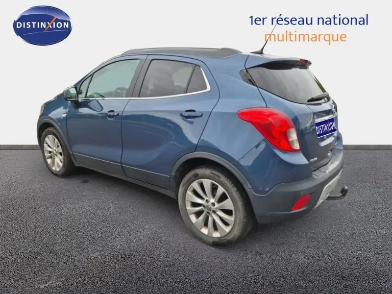 Opel Mokka bleu outremer vue 3/4 arrière droit, jantes alu et vitres arrière teintées visibles.