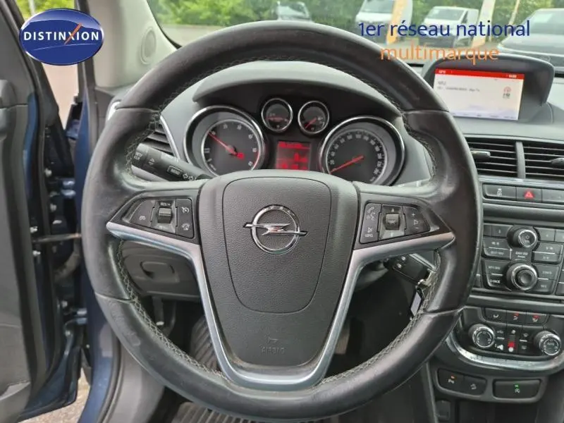Vue intérieure centrée sur le volant cuir multifonction d’un Opel Mokka bleu outremer avec tableau de bord et écran multimédia.