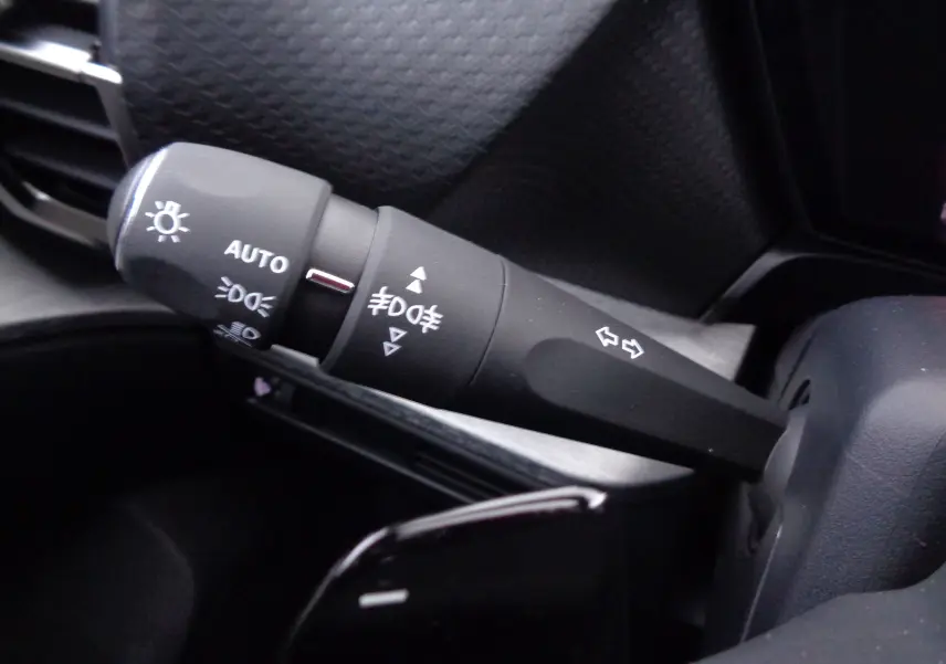 Gros plan sur la manette de clignotants et feux du tableau de bord noir du Citroën C5 X 2023 finition Feel Pack.