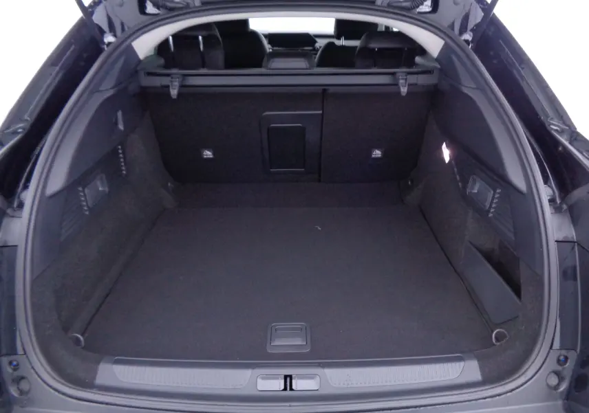 Coffre ouvert vu de l'arrière d'une Citroën C5 X noir métal, montrant un espace de chargement spacieux et bien fini.