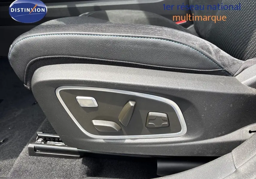 Gros plan sur les commandes électriques du siège conducteur en cuir noir avec surpiqûres bleues du Renault Austral hybride.