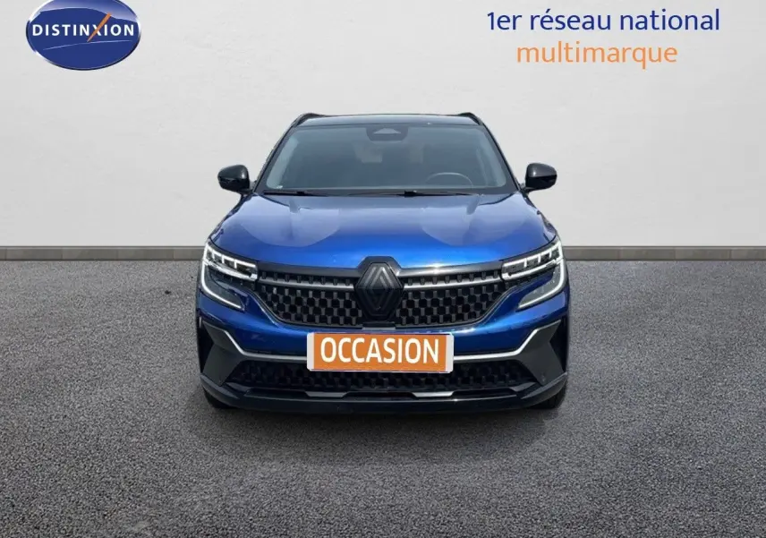 Vue frontale d'un Renault Austral E-Tech hybride bleu Iron Metal avec toit noir, calandre et phares LED distinctifs.