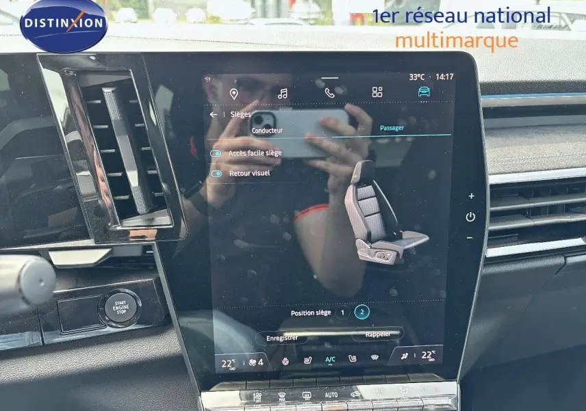 Gros plan sur l'écran tactile central du Renault Austral E-Tech bleu, affichant les réglages des sièges avec tableau de bord noir.