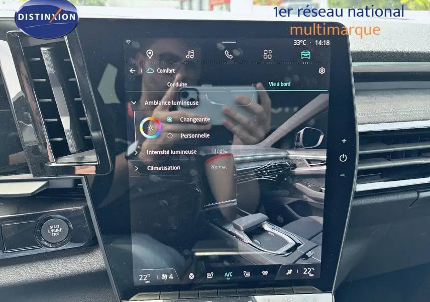 Vue rapprochée de l'écran tactile central du tableau de bord du Renault Austral E-Tech bleu, avec commandes et ventilation visibles.