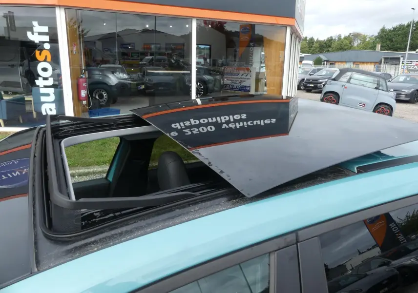 Toit ouvrant électrique ouvert sur le dessus d'une Jeep Avenger bleu métallisé 2024, vue rapprochée côté gauche.