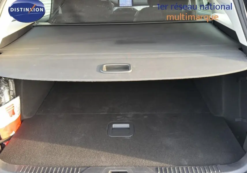 Coffre ouvert vu de l'arrière d'une Ford Focus SW noire, avec cache-bagages et intérieur sombre.