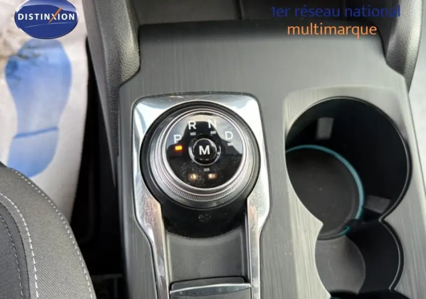 Gros plan sur la molette de sélection de la boîte automatique dans l'habitacle d'une Ford Focus SW noire.