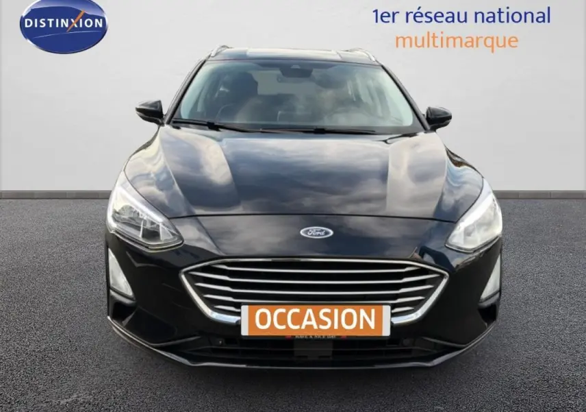 Vue frontale d'une Ford Focus SW noire 2019 avec calandre chromée et feux allumés sur fond neutre.