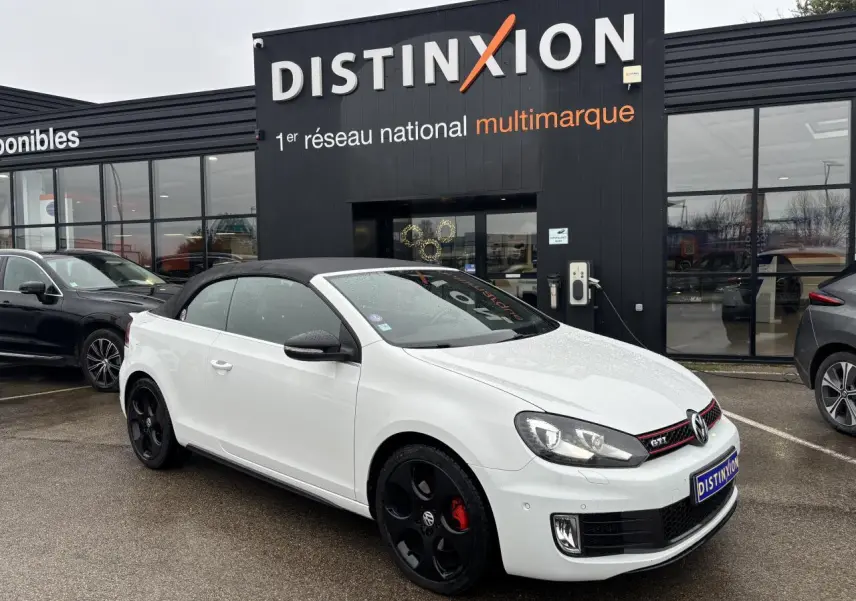 Volkswagen Golf VI Cabriolet blanc vue 3/4 avant avec toit noir et jantes noires distinctives.