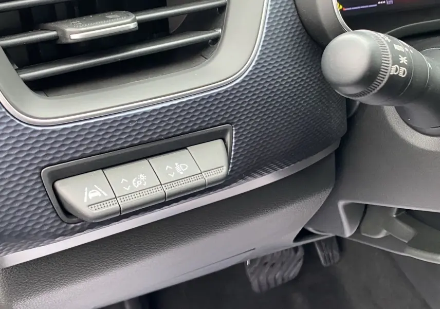 Détail des commandes d’aide à la conduite sur la partie gauche du tableau de bord du Renault Arkana noir 2024.