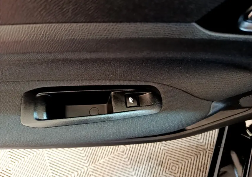 Poignée intérieure côté gauche de porte noire de Peugeot 308 Active Business 2020, avec bouton de verrouillage.