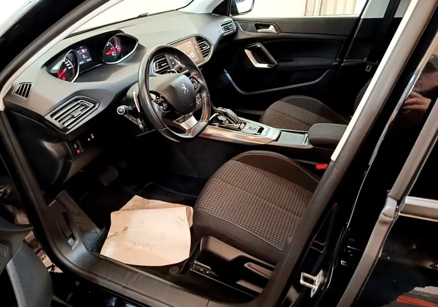 Intérieur noir de la Peugeot 308 2020, vue côté conducteur avec tableau de bord et volant multifonctions visibles.