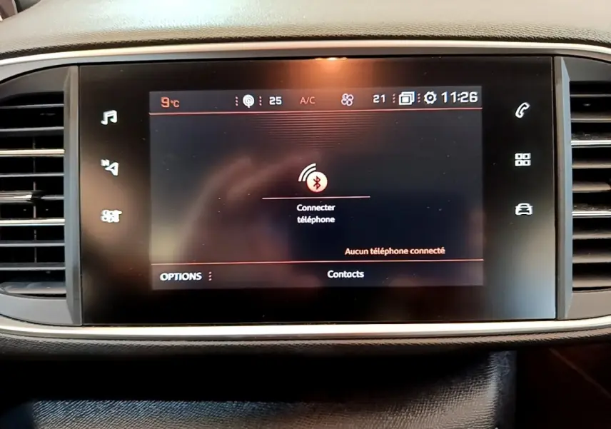 Écran tactile central de la Peugeot 308 2020 affichant la connexion Bluetooth pour téléphone, entouré de grilles d'aération.
