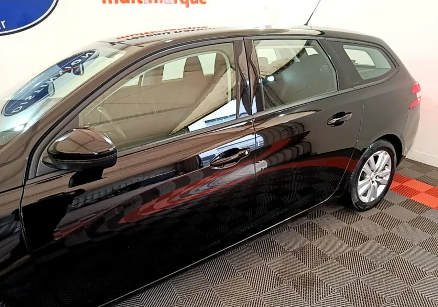 Profil côté gauche d'une Peugeot 308 noire 2020 en version break, avec jantes argentées et rétroviseur noir brillant.