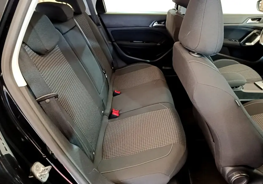 Vue intérieure côté gauche montrant la banquette arrière grise et les sièges avant du Peugeot 308 noir de 2020.