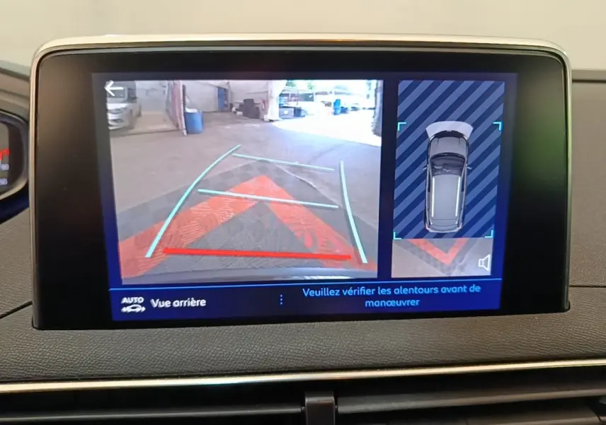 Écran tactile intérieur montrant la caméra de recul et l'aide au stationnement du Peugeot 3008 noir, vue arrière.
