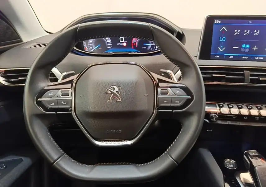 Vue rapprochée du volant cuir noir et du tableau de bord digital du Peugeot 3008 2022, avec écran tactile central.