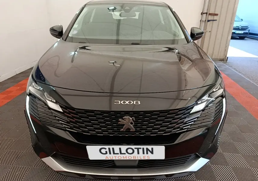 Vue frontale d’un Peugeot 3008 noir 2022 avec calandre noire et phares LED distinctifs allumés.