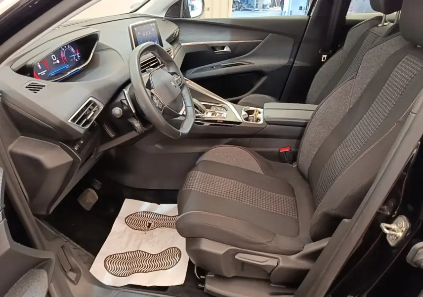 Vue intérieure côté conducteur du Peugeot 3008 noir 2022, montrant le volant cuir multifonctions et l’écran tactile central.