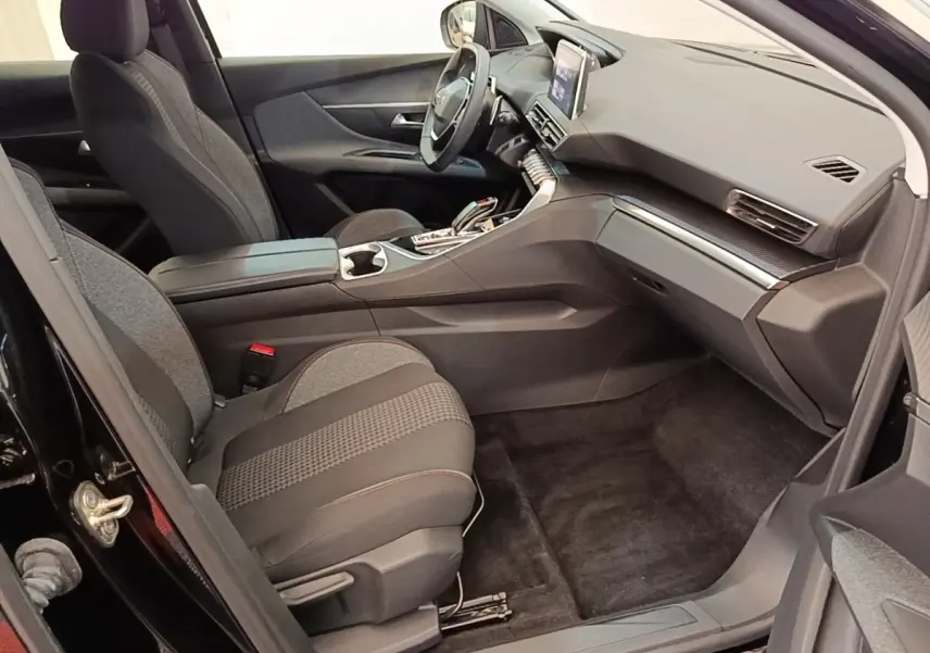 Vue intérieure côté passager avant du Peugeot 3008 noir 2022, avec tableau de bord moderne et sièges tissu gris.