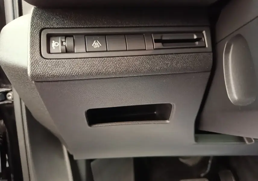 Vue intérieure côté gauche du tableau de bord noir du Peugeot 3008 2022 avec commandes d’éclairage et aide à la conduite.