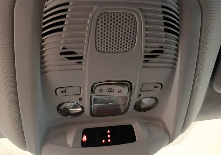 Vue en gros plan du plafonnier intérieur gris clair du Peugeot 3008 2022 avec boutons d’éclairage et détecteur intégré.