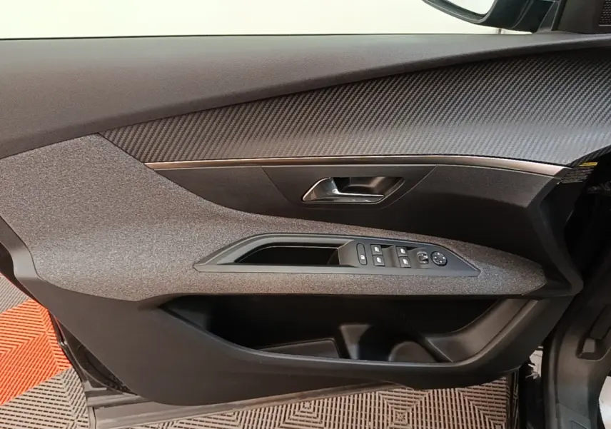 Vue intérieure du panneau de porte conducteur gris et noir du Peugeot 3008 2022 avec commandes des vitres et rétroviseurs.
