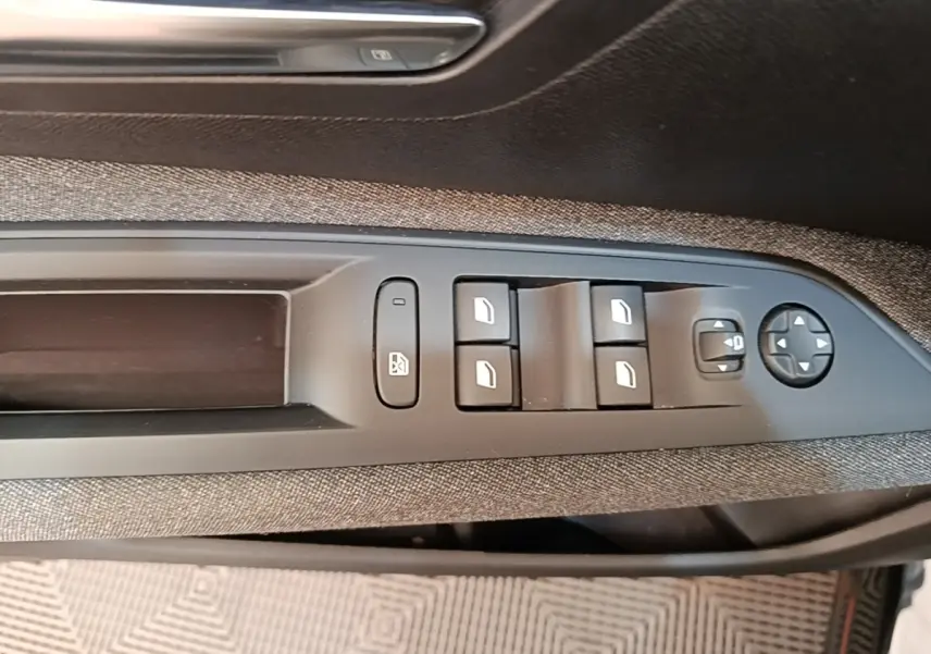Gros plan sur les commandes des vitres et rétroviseurs côté conducteur du Peugeot 3008 noir, finition Active Pack 2022.