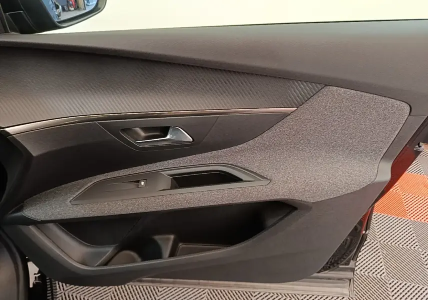 Vue intérieure du panneau de porte côté conducteur du Peugeot 3008 noir, avec habillage tissu et plastique noir.