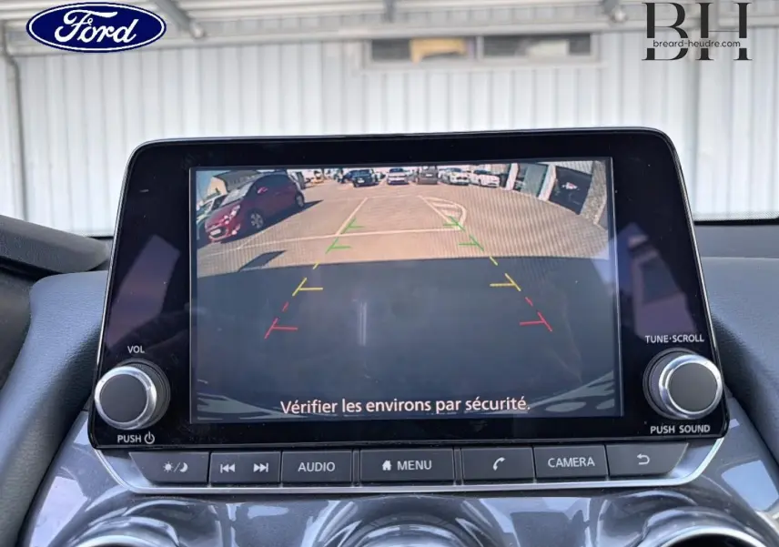 Écran tactile de caméra de recul dans un Nissan Juke noir métallisé, vue intérieure frontale du tableau de bord.
