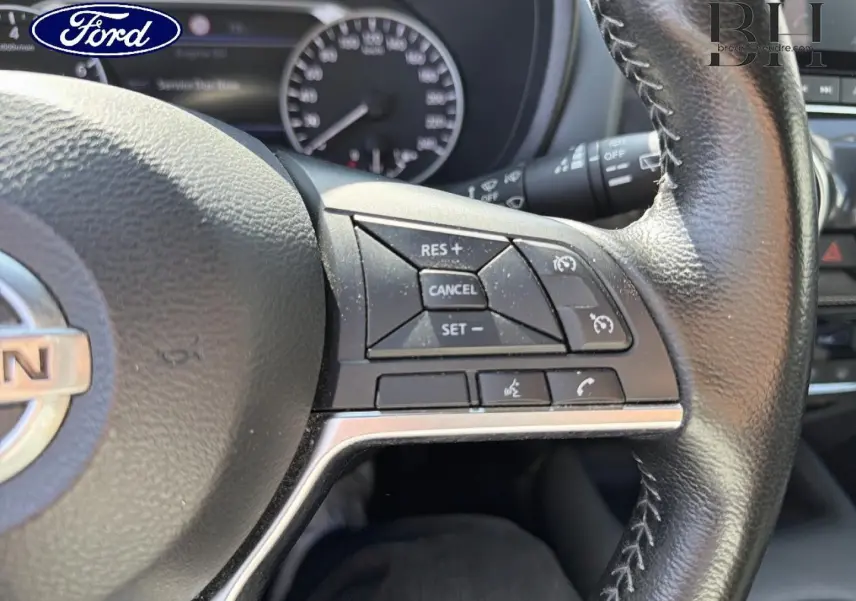 Vue rapprochée du volant cuir noir du Nissan Juke 2020, mettant en valeur les commandes multifonctions côté droit.