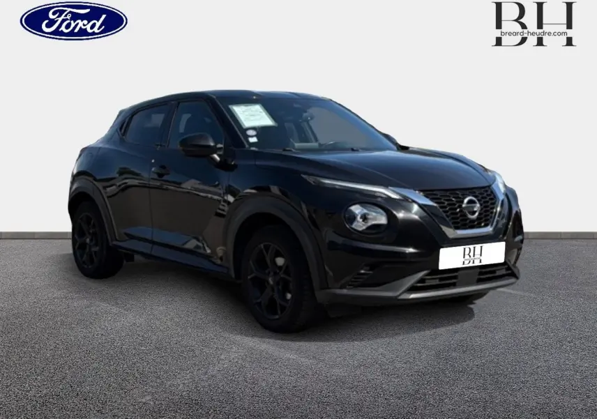 Nissan Juke noir métallisé vu en 3/4 avant droit, avec jantes noires et calandre distinctive V-Motion.