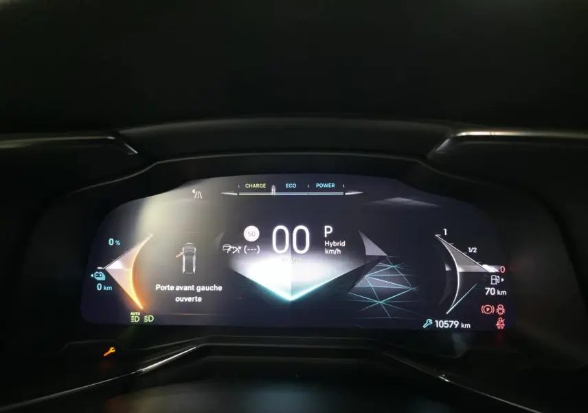 Tableau de bord numérique du DS7 Crossback E-Tense 2024 affichant vitesse, mode hybride et porte avant gauche ouverte.