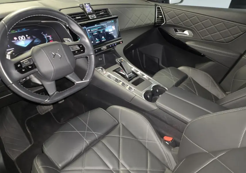 Vue intérieure côté conducteur du DS7 Crossback 2024, sellerie cuir noir avec console centrale et écran tactile.