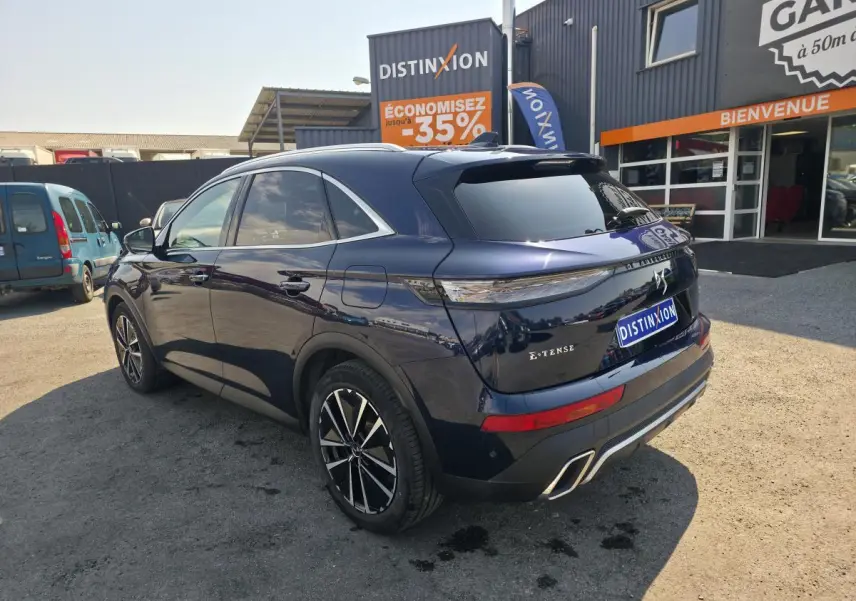 Vue 3/4 arrière droite d’un DS7 Crossback E-Tense bleu métallisé avec jantes 19’’ et double sortie d’échappement chromée.