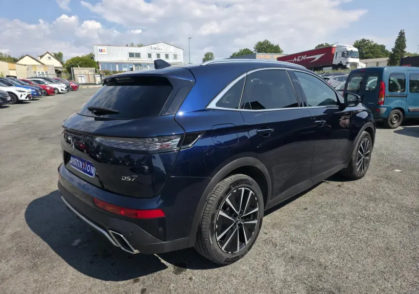Vue 3/4 arrière droite du DS7 Crossback E-Tense bleu métallisé avec jantes alliage et feux arrière 3D à LED.