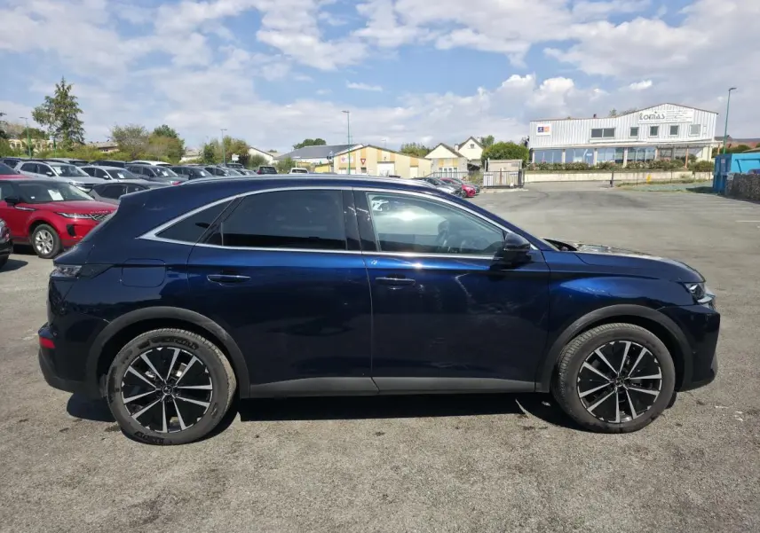 Vue latérale droite du DS7 Crossback E-Tense 225 bleu métallisé avec jantes alliage noires et vitres arrière surteintées.