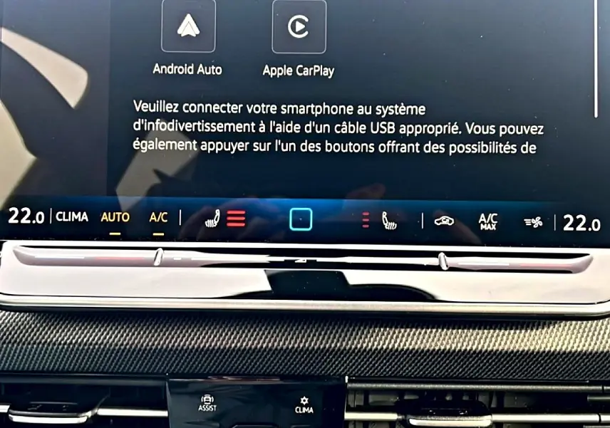 Détail de l’écran tactile central noir de la Volkswagen Golf 2026 avec commandes climatisation et connectivité smartphone.