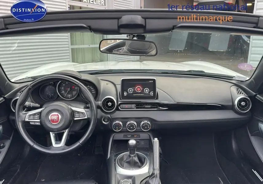 Vue intérieure frontale du tableau de bord noir de la FIAT 124 Spider Lusso 2017 avec volant cuir multifonctions et écran tactile.