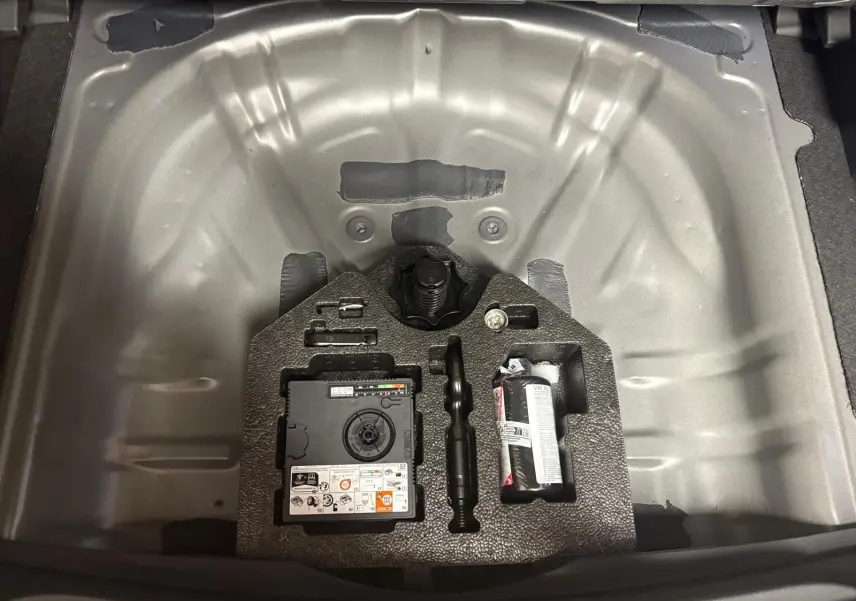 Coffre ouvert montrant la roue de secours et outils dans un CUPRA Formentor gris Graphène 2025.