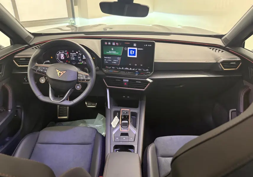 Intérieur du CUPRA Formentor 2025 vu de face, tableau de bord noir avec écran tactile et volant multifonction.