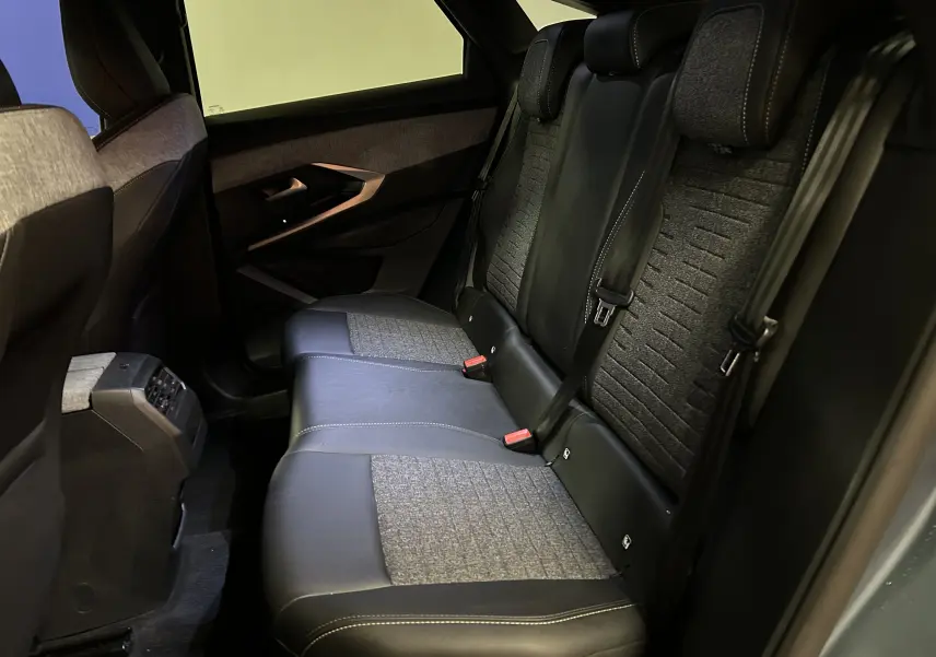 Vue intérieure côté droit des sièges arrière en cuir et tissu gris du Peugeot 3008 III Hybrid 145 Allure 2025.