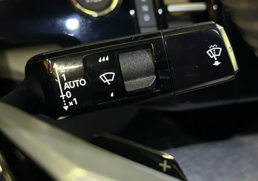 Gros plan sur la commande d'essuie-glace du Peugeot 3008 Bleu Ingaro, intérieur avec bouton start/stop visible en arrière-plan.