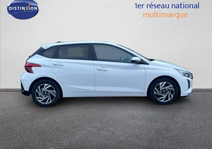 Profil droit d'une Hyundai i20 blanc atlas 2025 avec jantes alliage et vitres teintées, sur fond neutre.